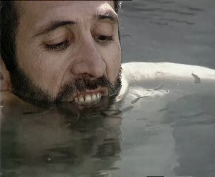 Close-up of man's face partially submerged in water.