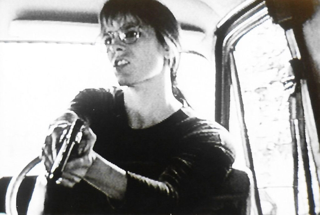 Scene from Cirsium Delectus, woman with gun.